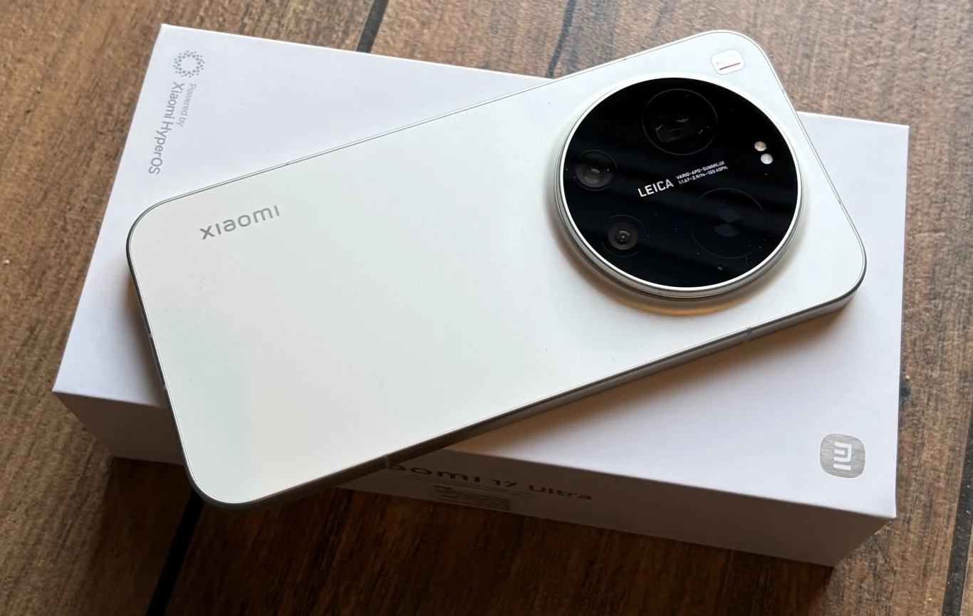 Premiera Xiaomi 17 i 17 Ultra. Znamy polskie ceny smartfonów. Biały smartfon Xiaomi z dużą, okrągłą wyspą aparatu z logo Leica, umieszczony na białym pudełku z brandingiem producenta, całość na drewnianym tle.
