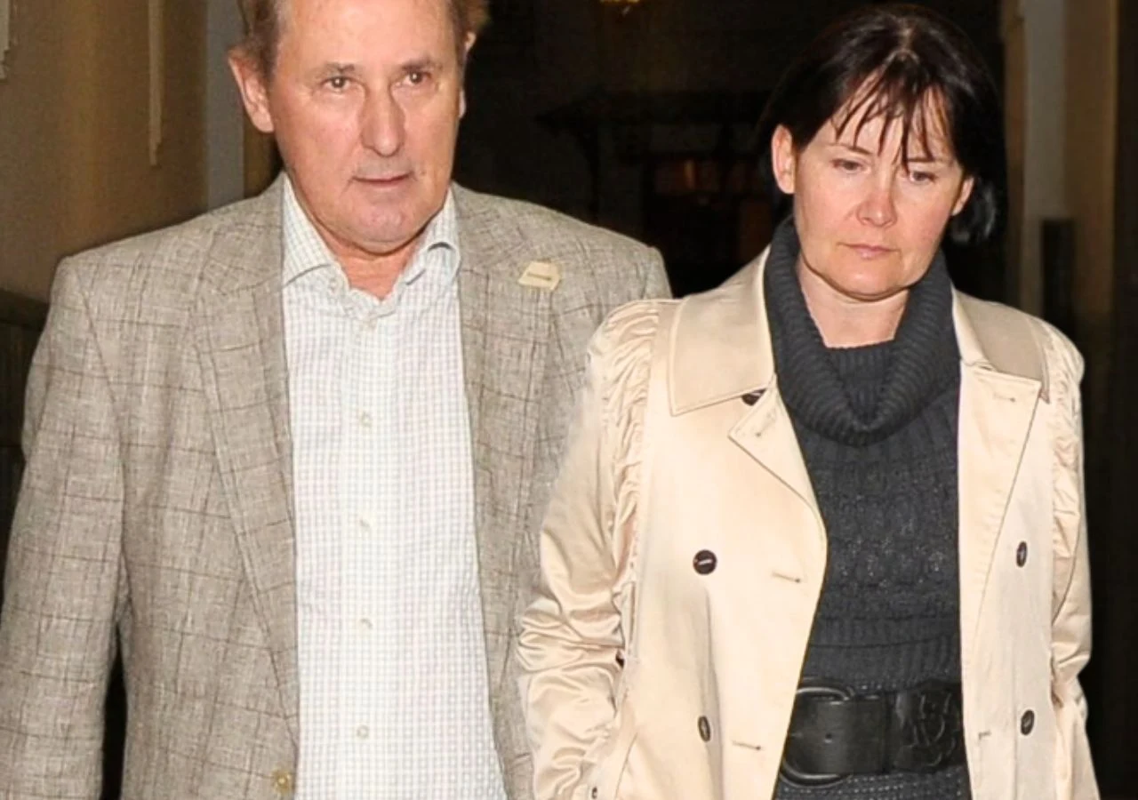 Piotr Skarga, Beata Aponowicz Para dorosłych osób idących razem korytarzem, mężczyzna w szarej marynarce i kobieta w jasnym płaszczu oraz ciemnym swetrze.