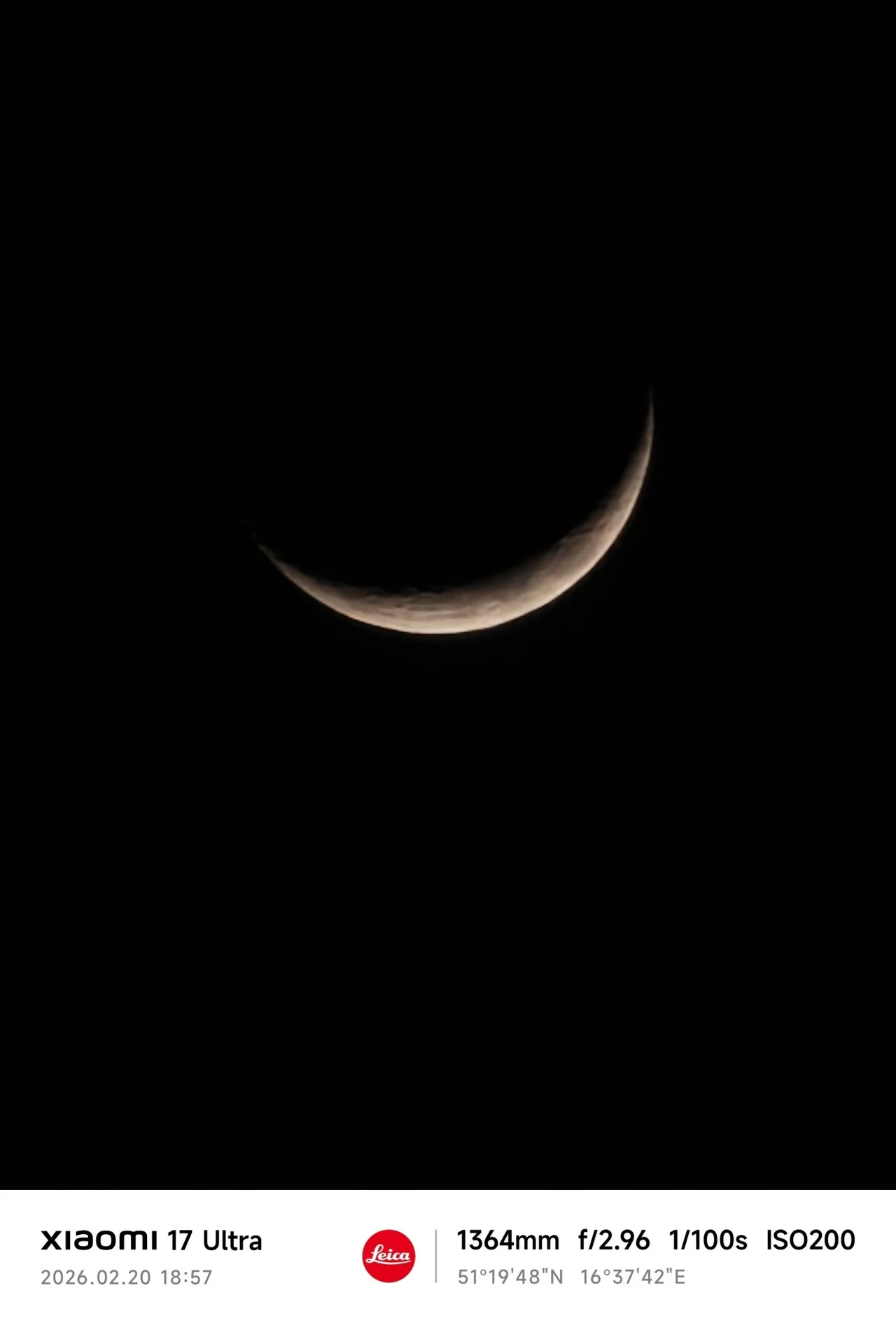 Księżyc w fazie sierpa na ciemnym, niemal całkowicie czarnym tle, dobrze widoczne charakterystyczne oświetlenie jednej krawędzi.