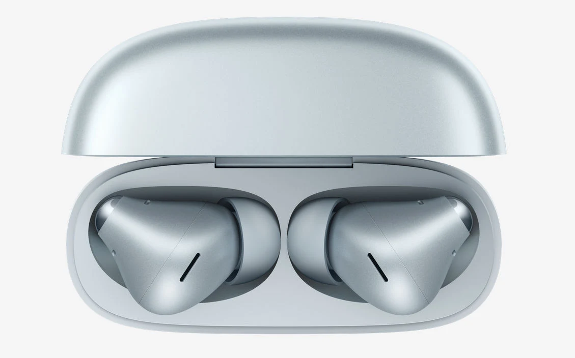 Srebrne bezprzewodowe słuchawki douszne umieszczone w otwartym etui ładującym o dopasowanym kolorze, z wyraźnie zaznaczonymi kształtami obu słuchawek.