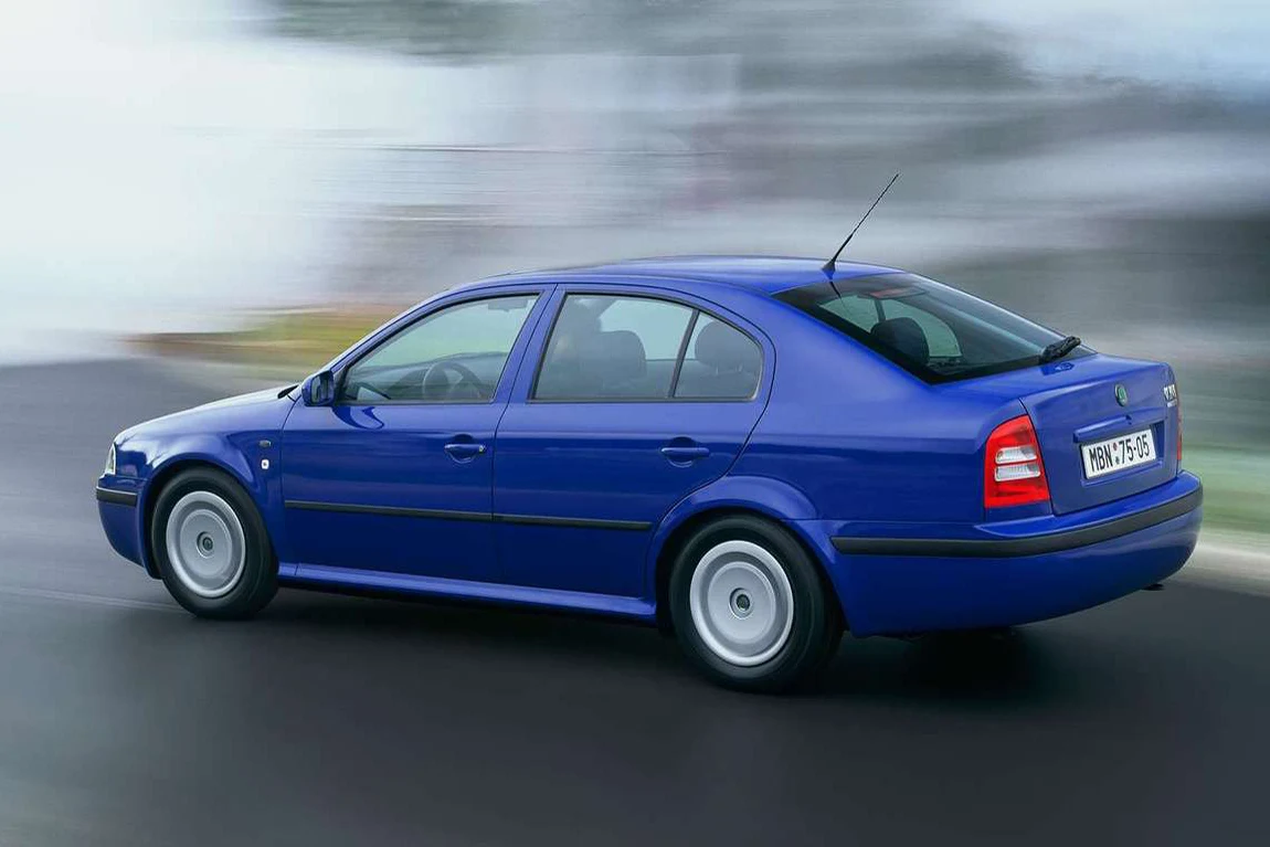 Niebieski samochód osobowy poruszający się dynamicznie po jezdni, widoczne są zamazane tło oraz wyraźny profil pojazdu będącego w ruchu.