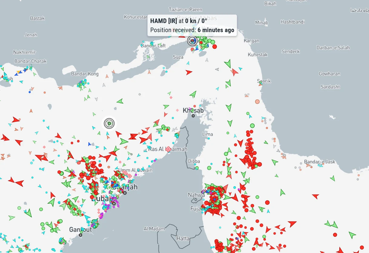 Mapa ruchu statków wokół cieśniny Ormuz z dużą liczbą symboli statków oznaczonych kolorowymi trójkątami i kółkami; widoczne są porty, miasta oraz szczegółowe oznaczenia pozycji statku HAMD, a także zróżnicowane gęstości ruchu wodnego w poszczególnych o...