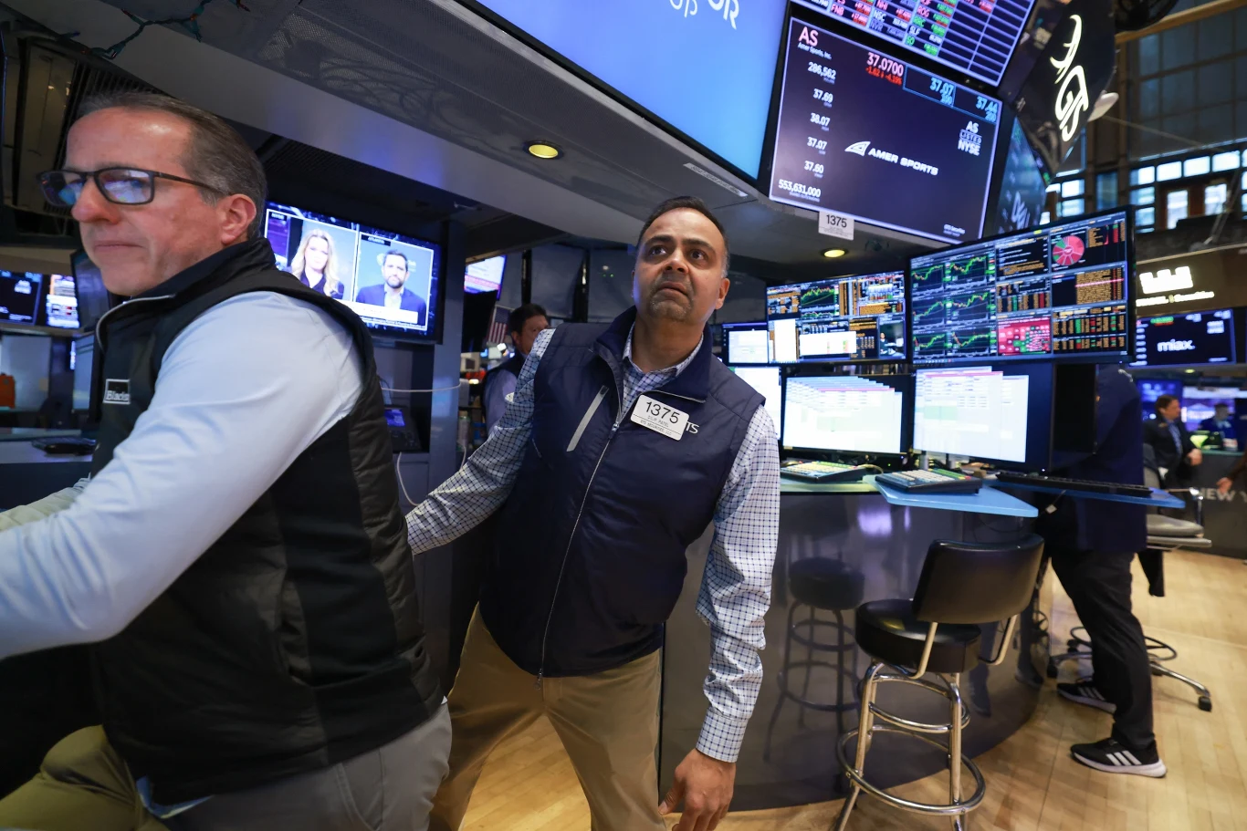 Poniedziałek przyniesie wzrosty cen ropy i złota - prognozują ekonomiści. Co stanie się na giełdach papierów wartościowych? Na zdj. NYSE (Wall Street). Zdj. ilustracyjne Dwóch maklerów giełdowych pracujących przy stanowiskach z wieloma monitorami wyświetlającymi notowania giełdowe oraz wykresy, w tle widoczne elementy sali giełdowej i inne osoby.