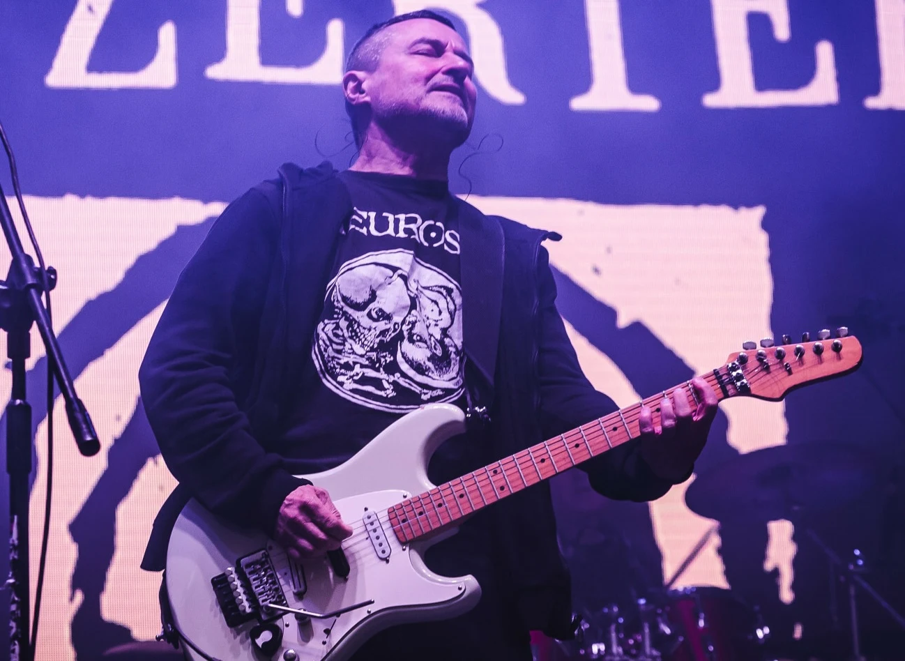 Robert "Robal" Matera z zespołu Dezerter Robert "Robal" Matera z zespołu Dezerter stoi na scenie grając na gitarze z zamkniętymi oczami.