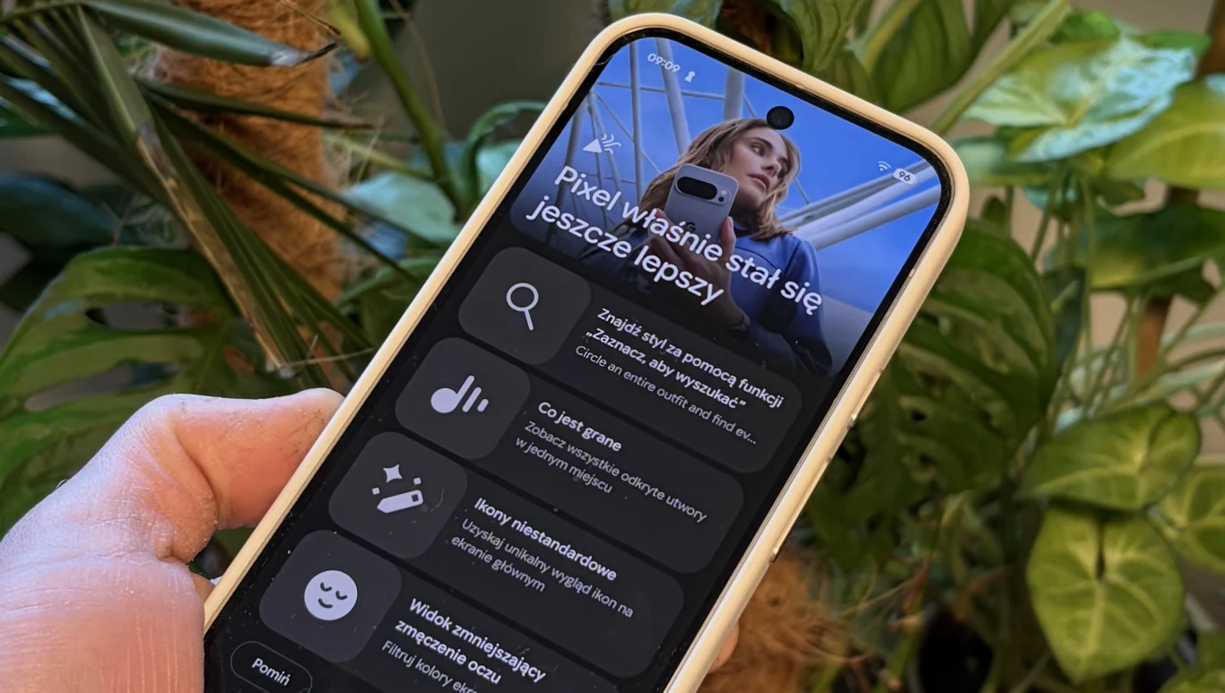 Android 16 dostaje tryb desktopowy. Google udostępnia nowości w Gemini. Dłoń trzymająca smartfon Google Pixel z aplikacją ukazującą nowości Androida 16 na tle zielonych roślin.