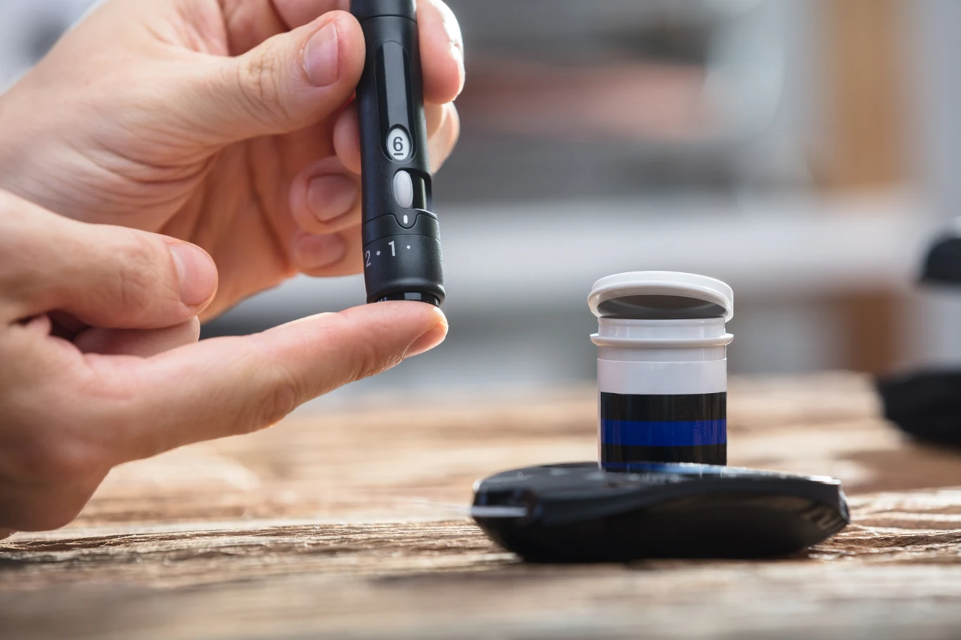 Ile spać, by uniknąć cukrzycy? Naukowcy podali dokładny czas Osoba przykłada glukometr do opuszka palca, obok pojemnik z paskami testowymi.