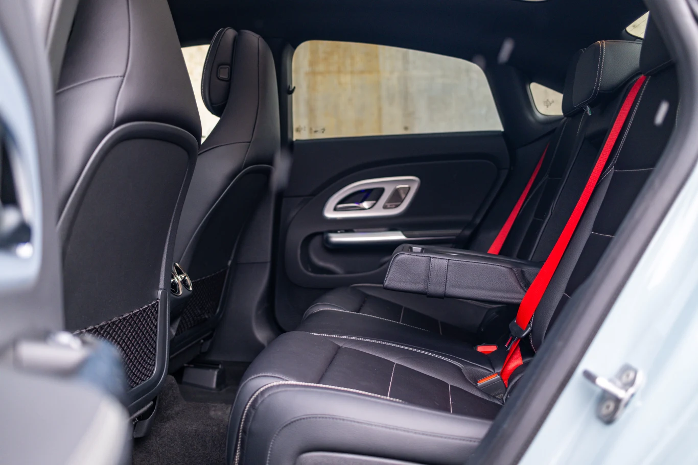 To, że czerwone pasy wymagają dopłaty nie jest niczym dziwnym, ale że dopłacić trzeba już za podłokietnik z tyłu to już tak. Czarne, skórzane tylne siedzenia samochodu z czerwonymi pasami bezpieczeństwa oraz rozłożonym podłokietnikiem pośrodku, eleganckie przeszycia i nowoczesne wykończenie wnętrza.