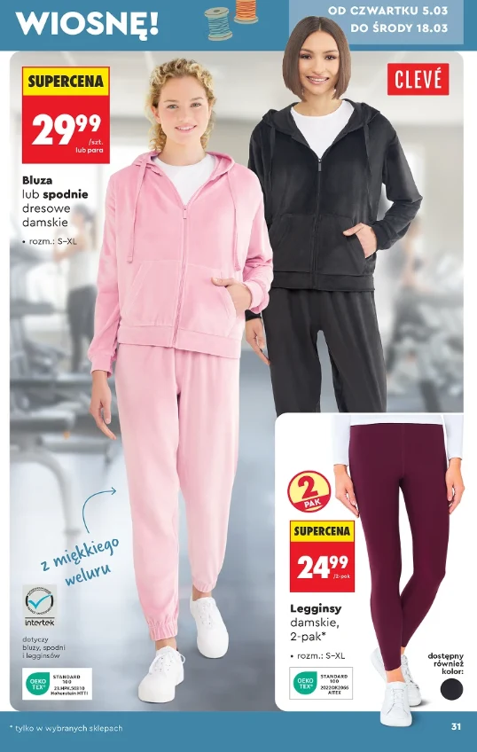 Dwie kobiety prezentują damskie dresy w pastelowym różu oraz czerni, z miękkiego weluru, oraz bordowe legginsy sportowe, promowane jako część wiosennej oferty z wyróżnionymi niskimi cenami.