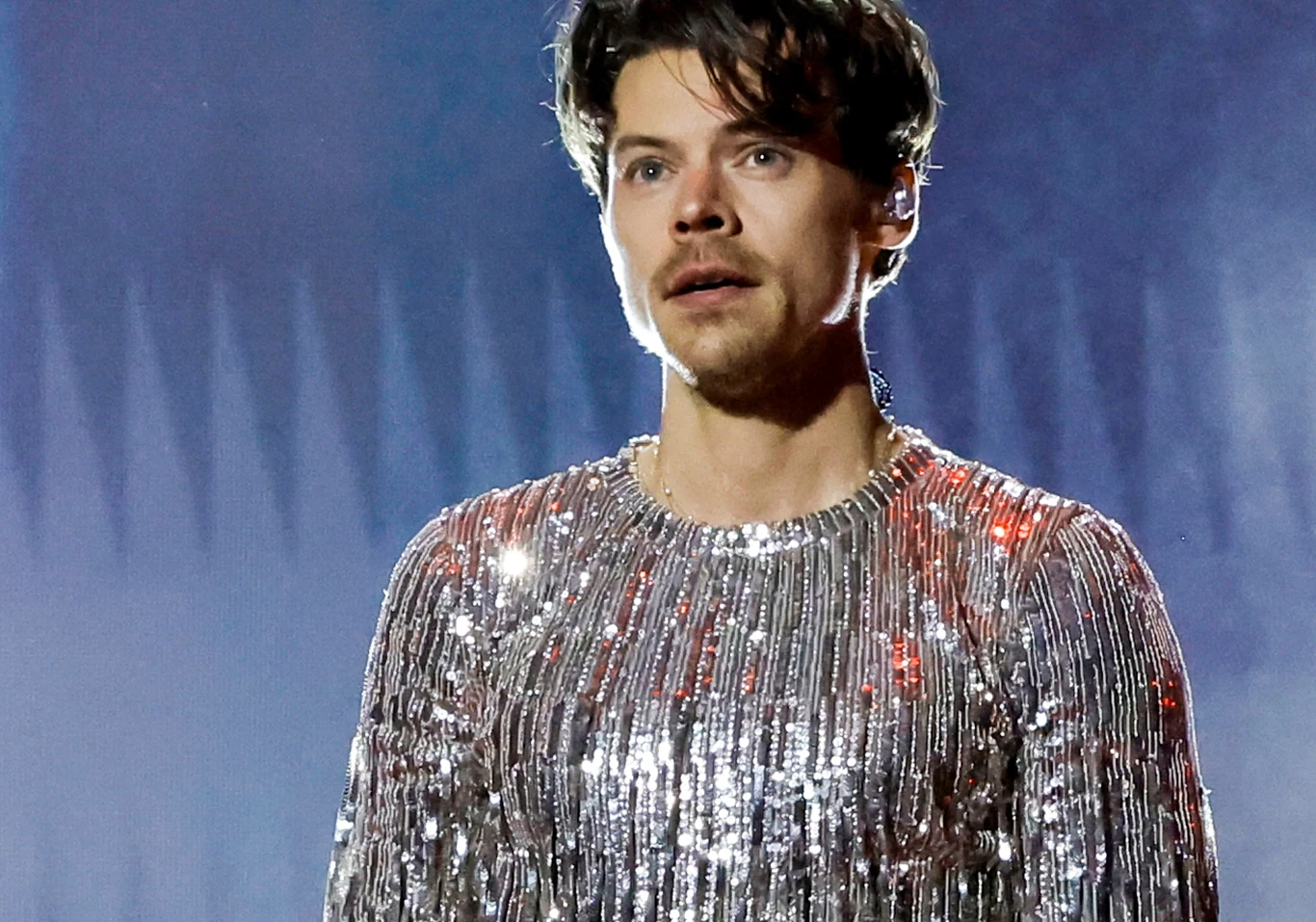 Harry Styles podzielił się refleksjami w rozmowie z Murakamim Harry Styles stoi na scenie w srebrnej cekinowej bluzce.