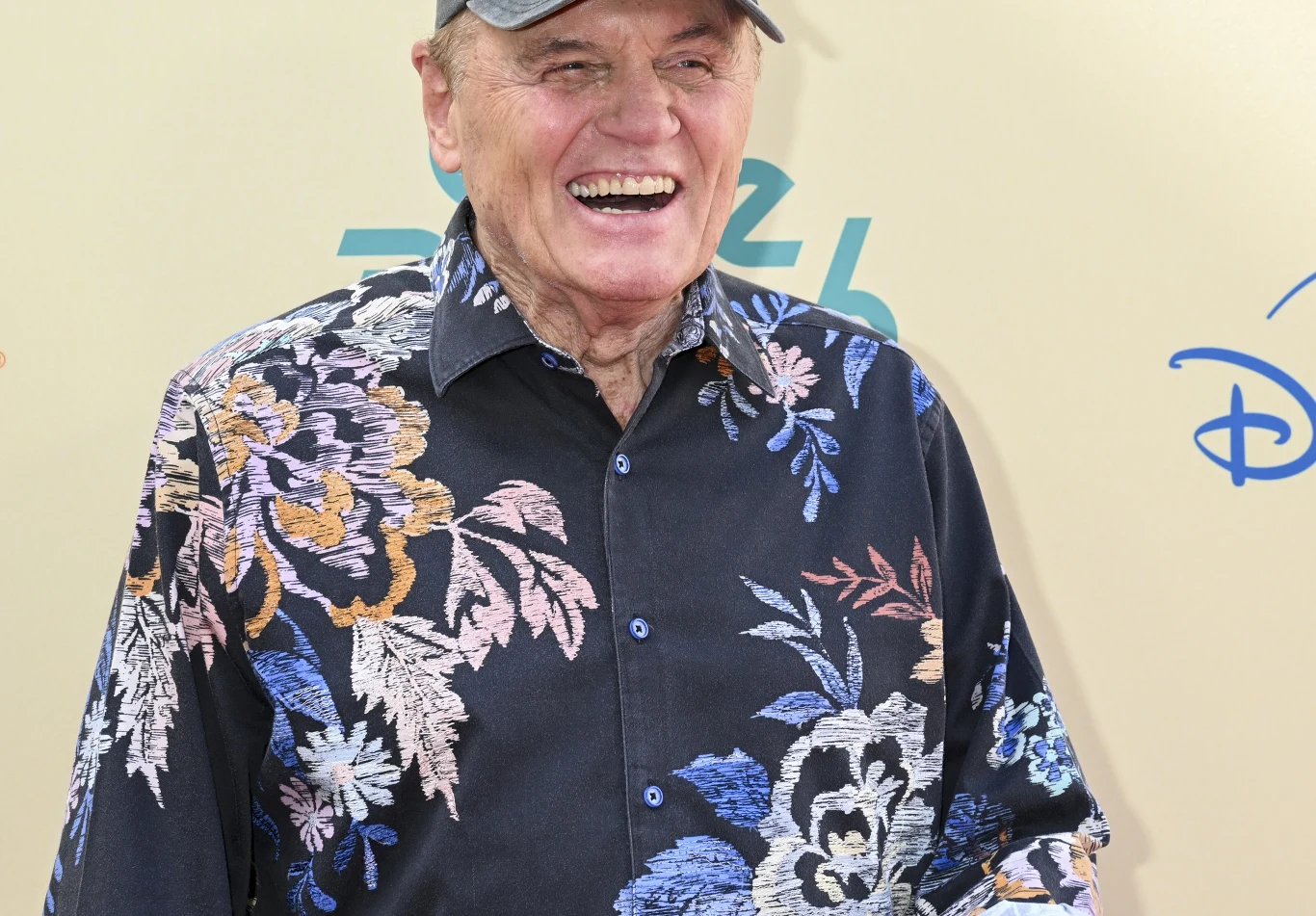 Bruce Johnston odchodzi z The Beach Boys Bruce Johnston uśmiecha się do zdjęcia. Ubrany jest w hawajską koszulę i pozuje na żółtym tle