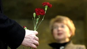 Mężczyzna z goździkiem w dłoni