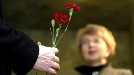 Mężczyzna z goździkiem w dłoni