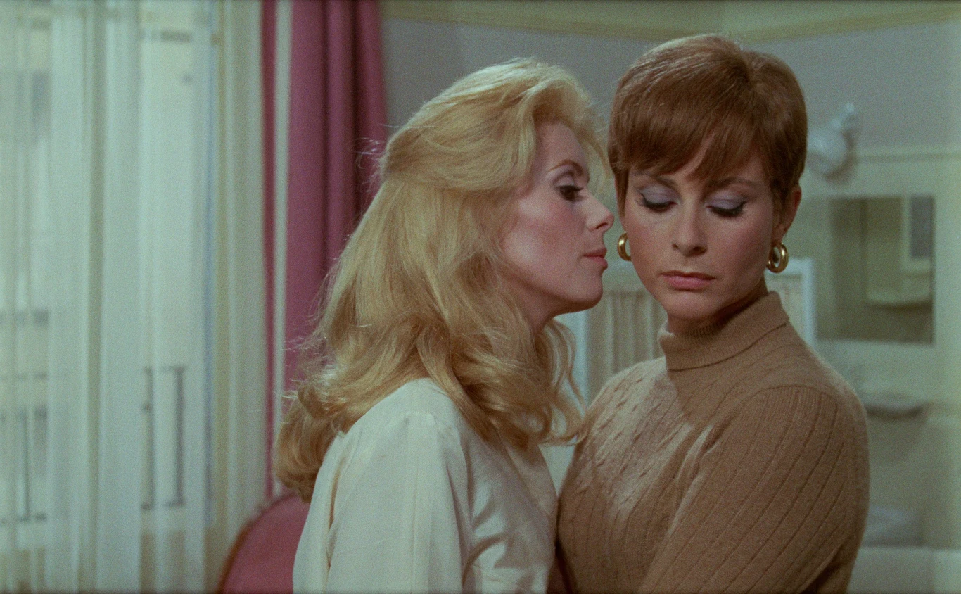 "Piękność dnia" Dwie eleganckie kobiety w jasnym pomieszczeniu; jedna blondynka, druga brunetka. Kadr z filmu "Piękność dnia".