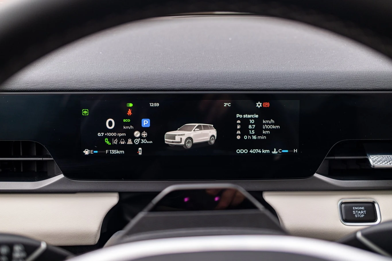 Cyfrowy panel wskaźników samochodu elektrycznego z widocznymi informacjami o prędkości, poziomie naładowania baterii, dystansie oraz graficzną wizualizacją pojazdu pośrodku ekranu.