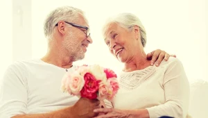 Dojrzała para, on wręcza jej kwiaty