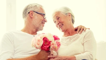 Dojrzała para, on wręcza jej kwiaty