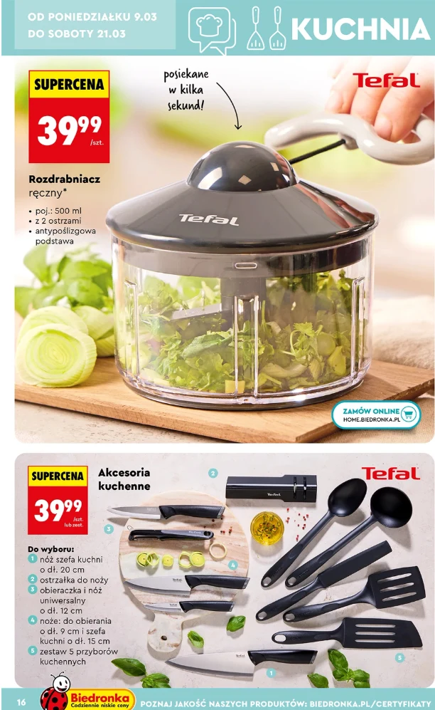 Ręczny rozdrabniacz Tefal z pokrojonymi warzywami w przezroczystym pojemniku, obok akcesoria kuchenne firmy Tefal, takie jak łopatki, łyżki i obieraczka, wszystko na jasnym blacie; ceny promocyjne i logo Biedronka widoczne na dole.