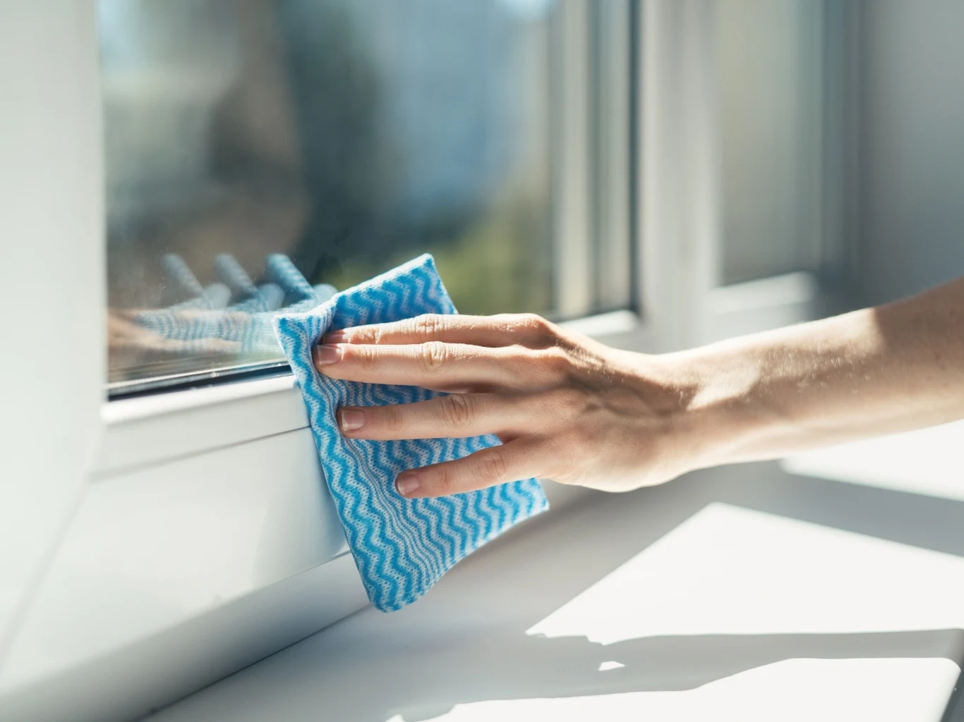 Przecieranie ram okiennych za pomocą ściereczki. 