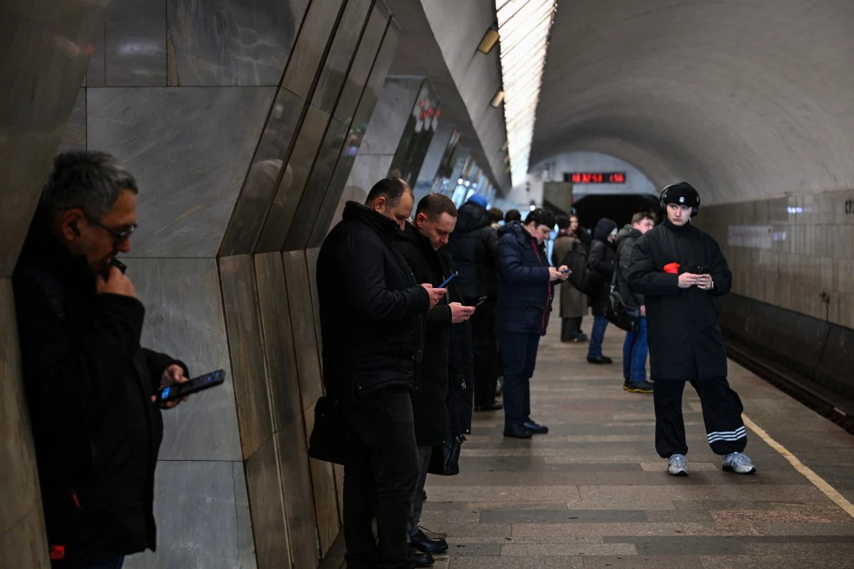 W Moskwie i Petersburgu dochodziło w ostatnich dniach do wyłączanie internetu Osoby w ciemnych kurtkach na peronie metra w Moskwie lub Petersburgu patrzą w telefony, w tle tunel i zegar.