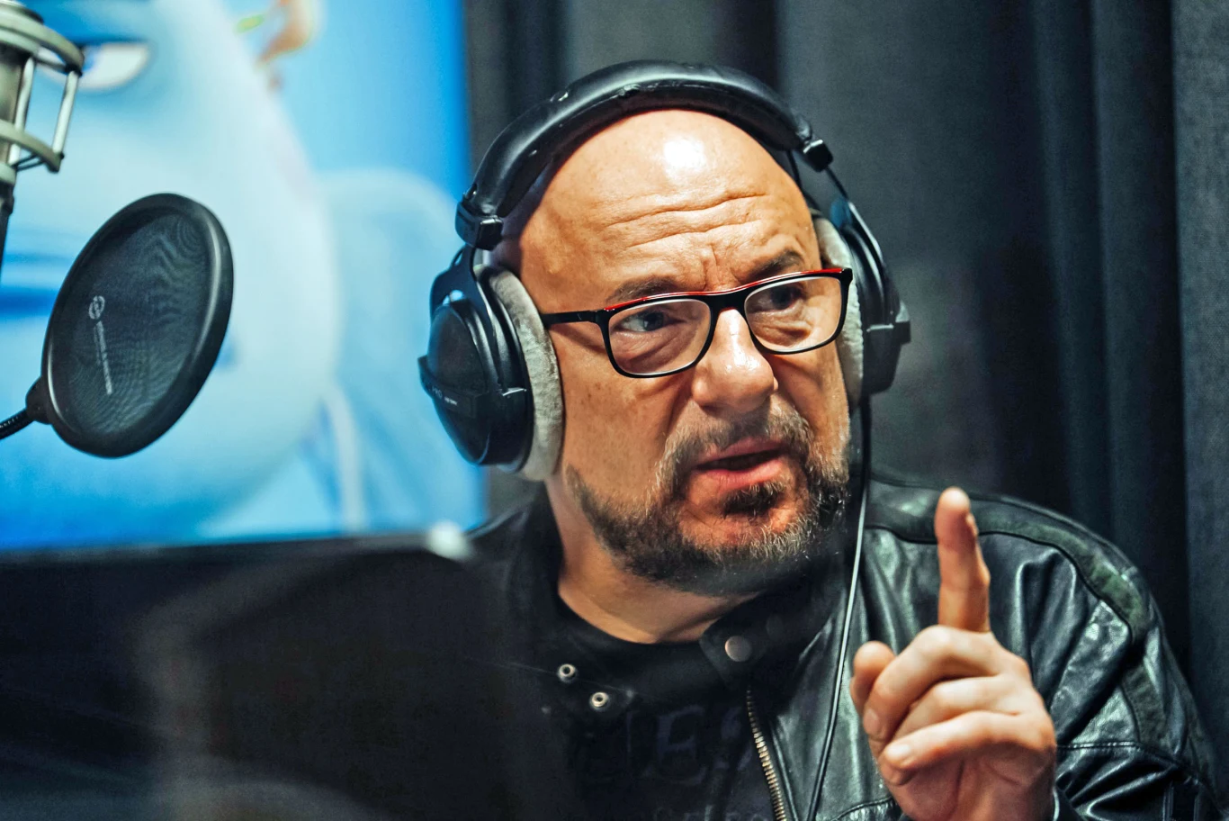 Głosu tytułowemu Panu Rybie użyczył Piotr Gąsowski Piotr Gąsowski w kabinie nagraniowej, w okularach i słuchawkach, gestykuluje przy mikrofonie na tle niebieskim.