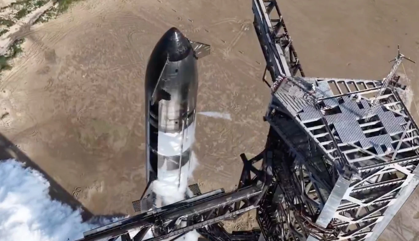 Rakieta Starship V3 SpaceX na stanowisku startowym, otoczona konstrukcją, z parą z systemu chłodzenia