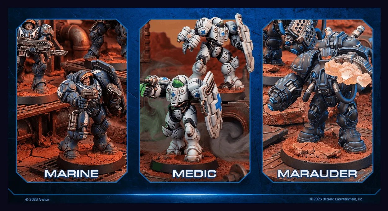 Trzy figurki futurystycznych żołnierzy w zbrojach bojowych ustawione na czerwono-brązowym terenie: po lewej postać z karabinem, pośrodku medyk z oznaczeniem krzyża na pancerzu i podniesioną ręką, po prawej ciężko opancerzony wojownik z wybuchającym poc...