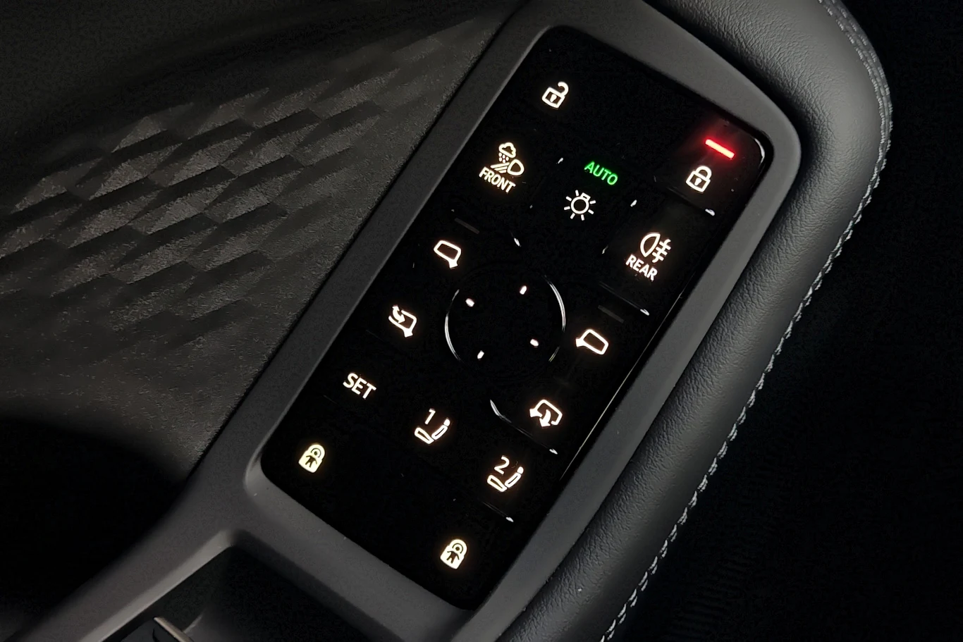 Panel sterowania szybami i lusterkami bocznymi w drzwiach samochodu z podświetlanymi przyciskami do blokady drzwi, ustawień lusterek oraz sterowania szybami przednimi i tylnymi.