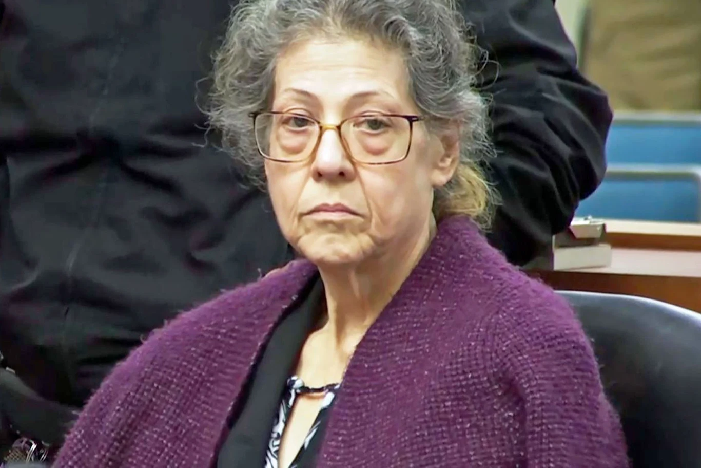 Kadr z filmu "Idealna sąsiadka" Kadr z filmu "Idealna sąsiadka": starsza kobieta w okularach i fioletowym swetrze siedzi w sali rozpraw.
