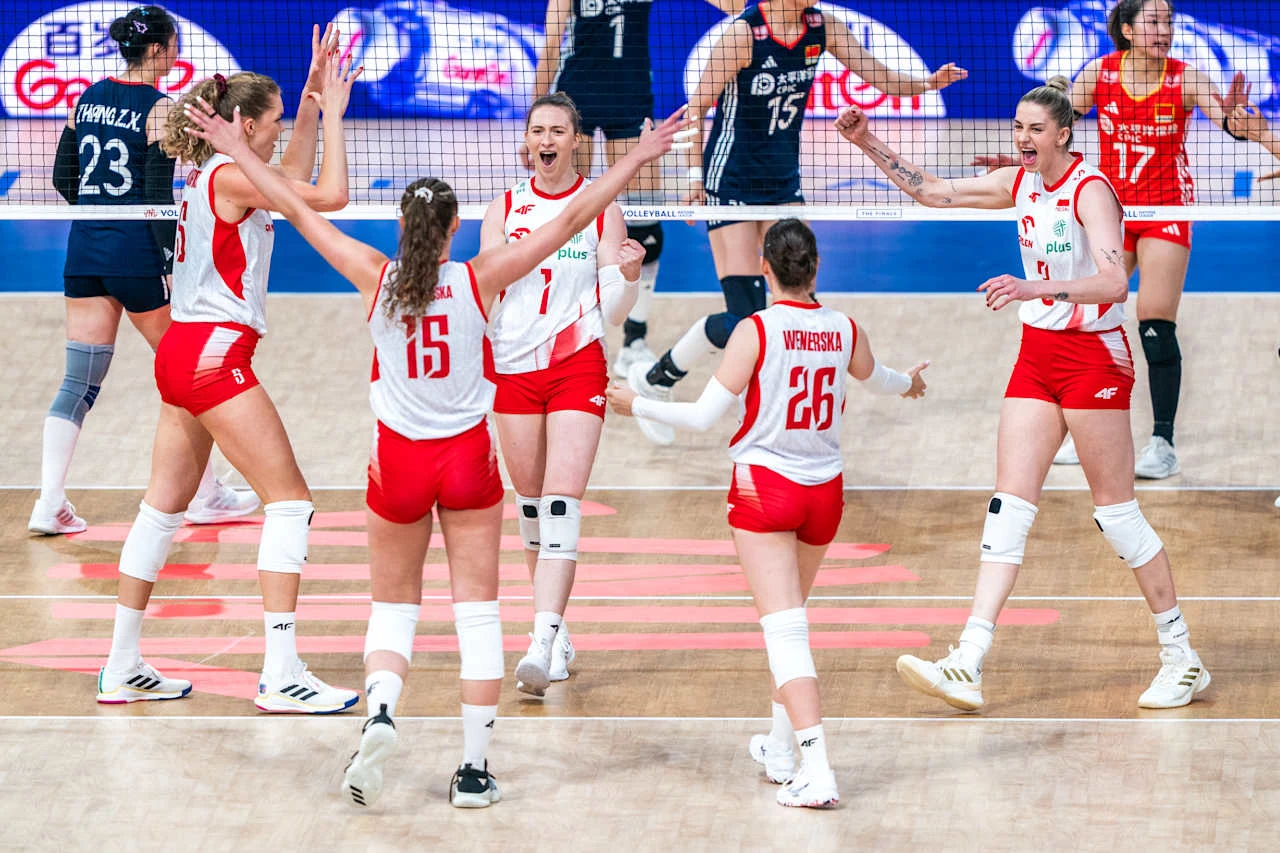 Polska drużyna siatkarek w czerwono-białych strojach świętuje zdobycie punktu, będąc zjednoczona i radosna na środku boiska podczas meczu, na drugim planie widać zawodniczki drużyny przeciwnej po drugiej stronie siatki.