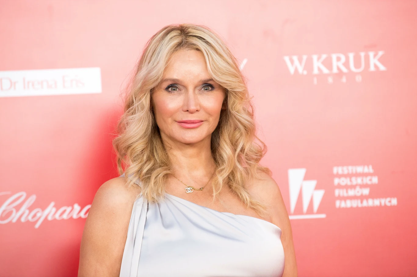 Katarzyna Śmiechowicz Katarzyna Śmiechowicz w białej sukni na tle czerwonej ścianki na festiwalu filmowym.