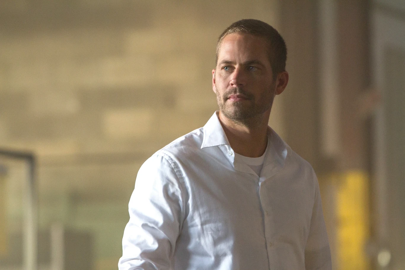 Paul Walker w filmie "Szybcy i wściekli 7" Paul Walker jako Brian O'Conner w białej koszuli na planie filmu "Szybcy i wściekli 7".