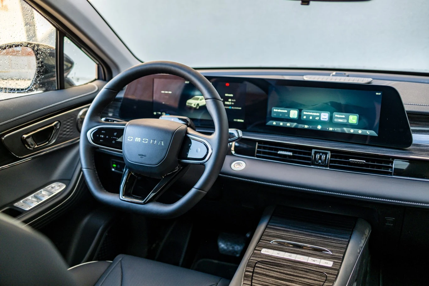 nowoczesne wnętrze samochodu z dużym dotykowym ekranem multimedialnym, cyfrowymi wskaźnikami na desce rozdzielczej i eleganckim panelem sterowania wykończonym materiałem przypominającym drewno