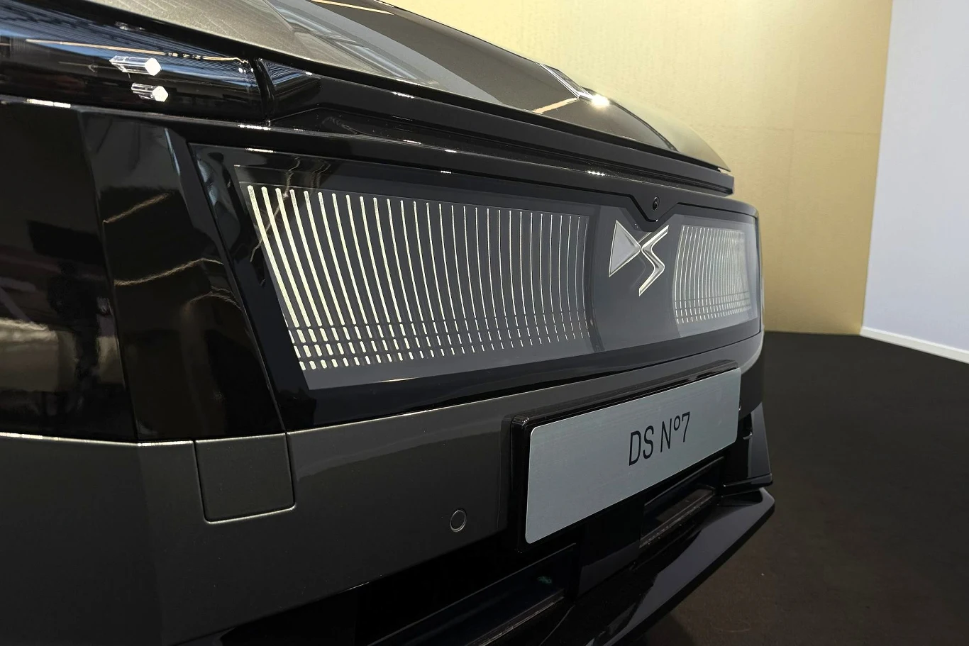 czarny przód samochodu elektrycznego z charakterystycznym logo DS oraz futurystycznym pionowym wzorem świateł i tablicą rejestracyjną z napisem DS N°7