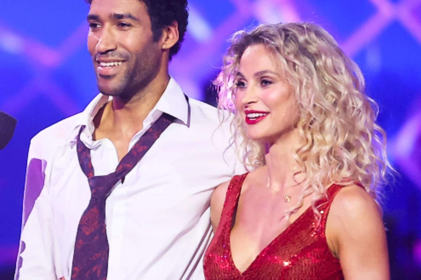 Gamou Fall, Hanna Żudziewicz Gamou Fall i Hanna Żudziewicz w strojach tanecznych na scenie „Tańca z gwiazdami”, oświetleni kolorowym światłem.