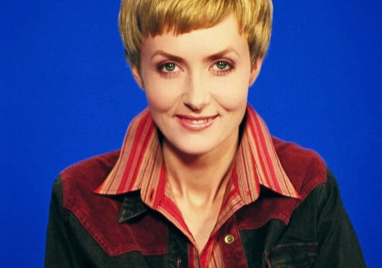 Agnieszka Wróblewska Agnieszka Wróblewska uśmiechnięta na niebieskim tle, ubrana w czerwoną wzorzystą koszulę i czerwono-granatową kurtkę.