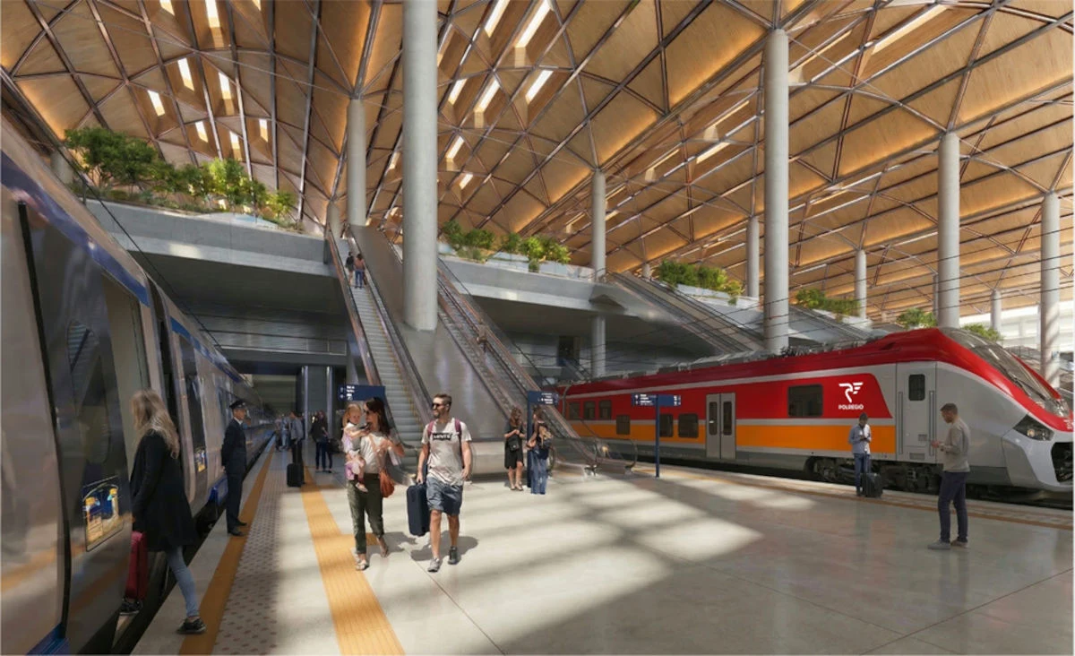 nowoczesny przestronny dworzec kolejowy z dużą ilością światła dziennego, dwa pociągi stojące przy peronie, podróżni przemieszczający się po hali oraz schody prowadzące na wyższy poziom stacji