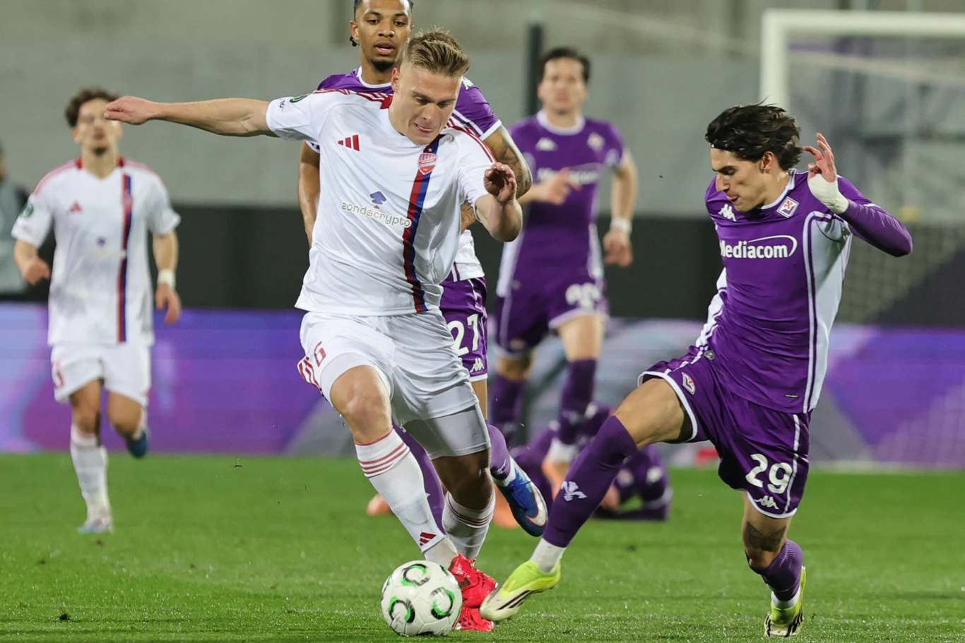 Oskar Repka i piłkarz Fiorentiny walczą o piłkę podczas meczu Ligi Konferencji, dynamiczna rywalizacja na boisku