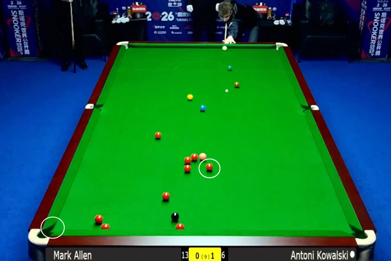 zielony stół bilardowy z rozstawionymi kolorowymi bilami, zawodnik skoncentrowany nad białą bilą przygotowujący się do uderzenia, elektroniczny licznik punktów wskazujący aktualny wynik meczu pomiędzy Markiem Allenem a Antonim Kowalskim