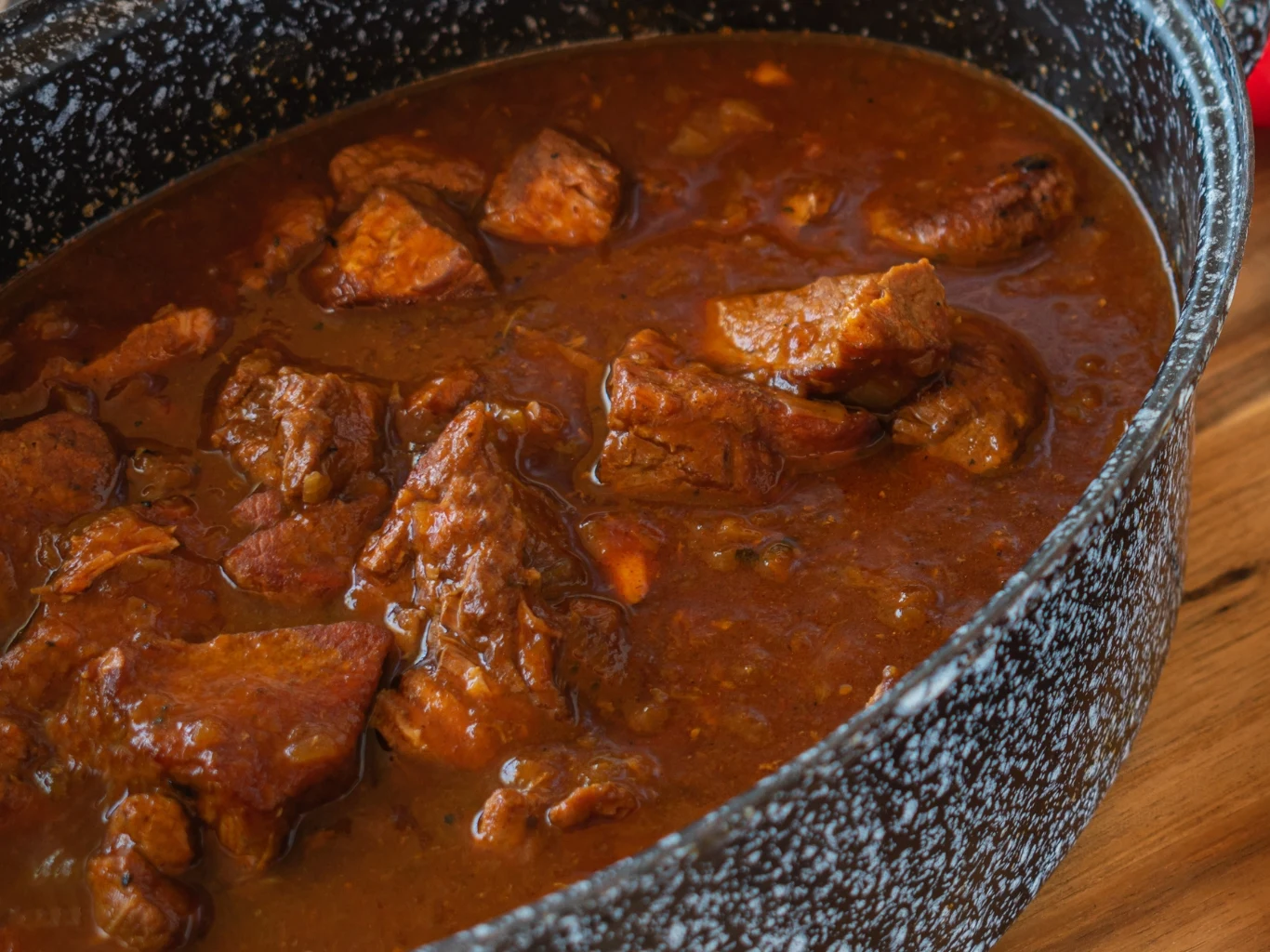 Marynata z popularnego napoju zmiękczy nawet najtwardsze mięso. Gulasz z dużymi kawałkami wołowiny w ciemnym sosie, duszony w garnku o marmurkowej powierzchni.