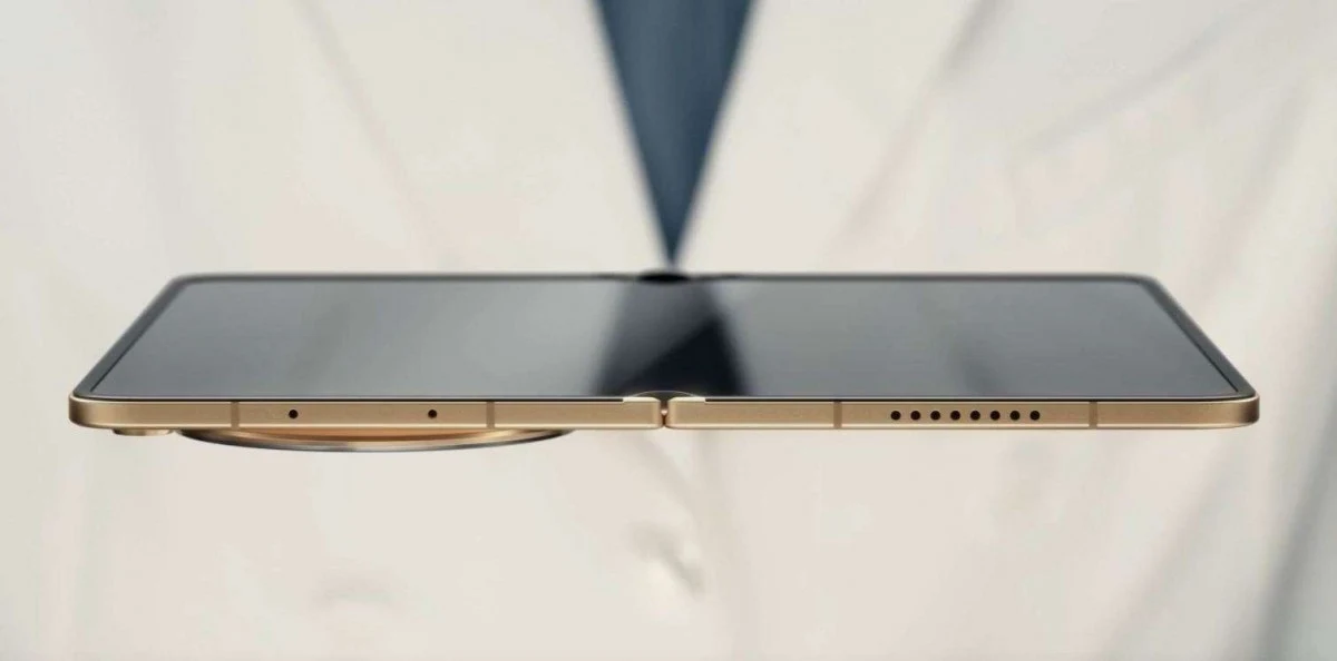 Premiera Oppo Find N6. Znamy ceny smartfona i specyfikację. Oppo Find N6 w kolorze złotym, bardzo cienki, z płaskim ekranem, widziany z profilu na tle białego fartucha.