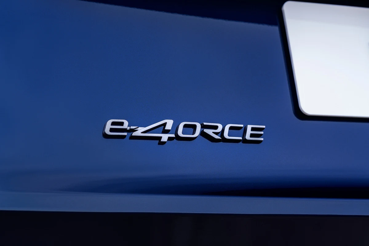 chromowany emblemat e-4ORCE na błyszczącej, ciemnoniebieskiej karoserii samochodu obok fragmentu tablicy rejestracyjnej