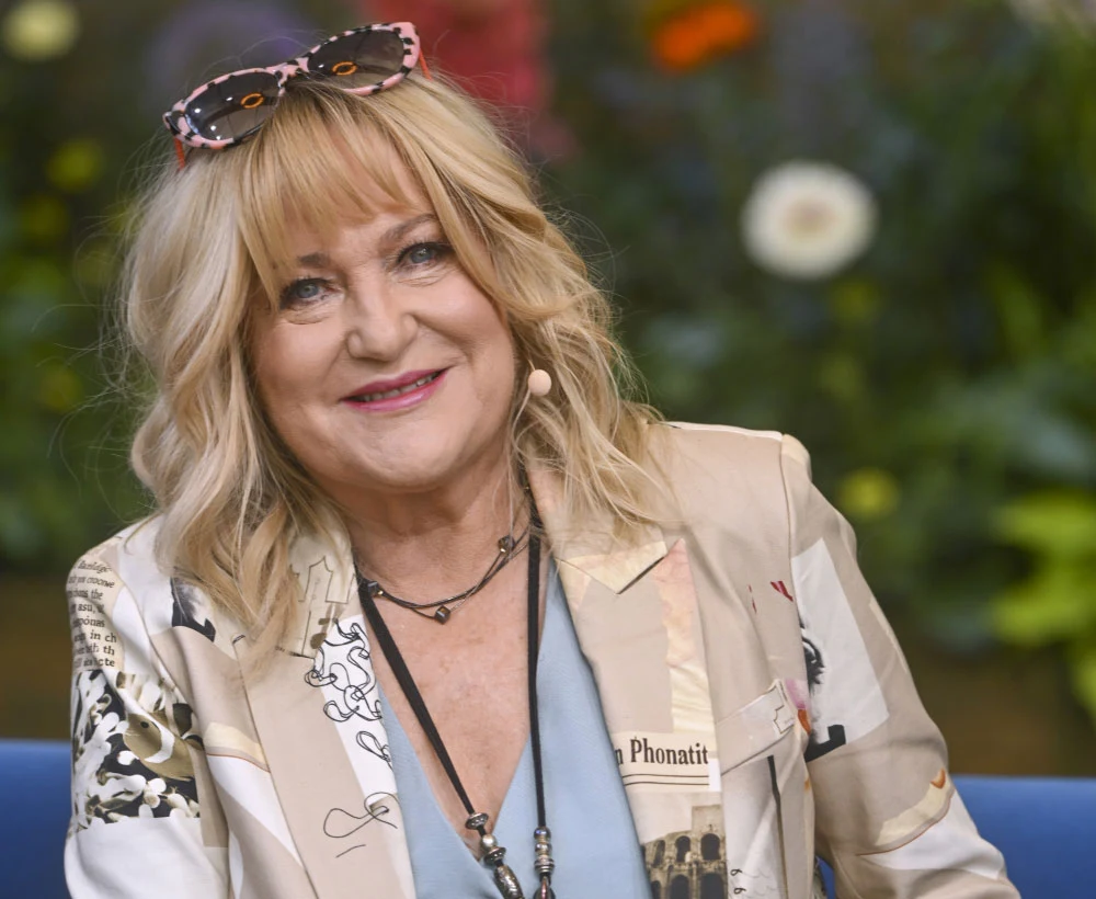 Marlena Drozdowska po latach ponownie nagrała wokal do piosenki "Radość o poranku" Marlena Drozdowska w beżowej marynarce i okulary przeciwsłonecznych, siedzi wśród zieleni i kwiatów.