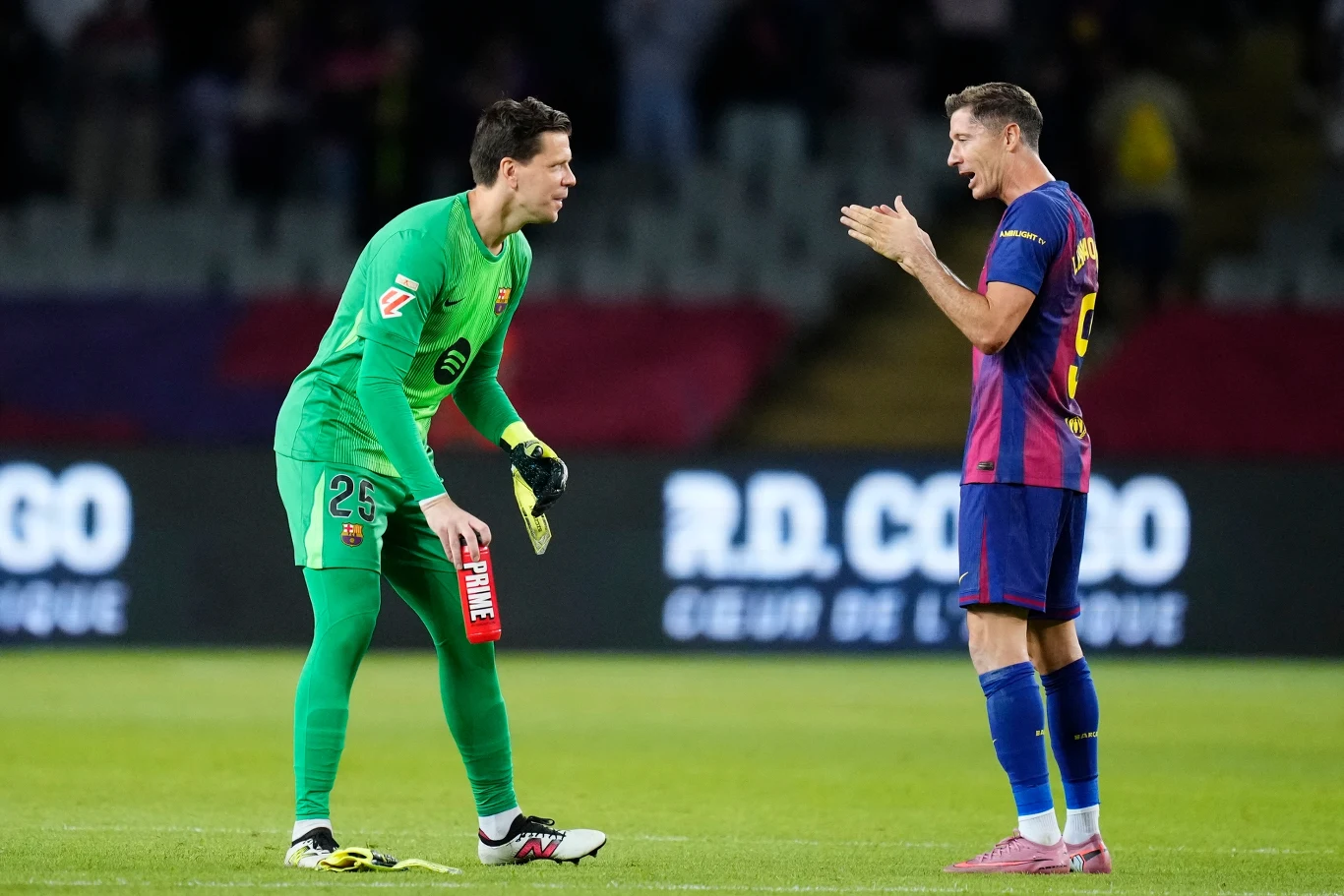 Wojciech Szczęsny i Robert Lewandowski w strojach meczowych FC Barcelona podczas rozmowy na boisku La Liga.