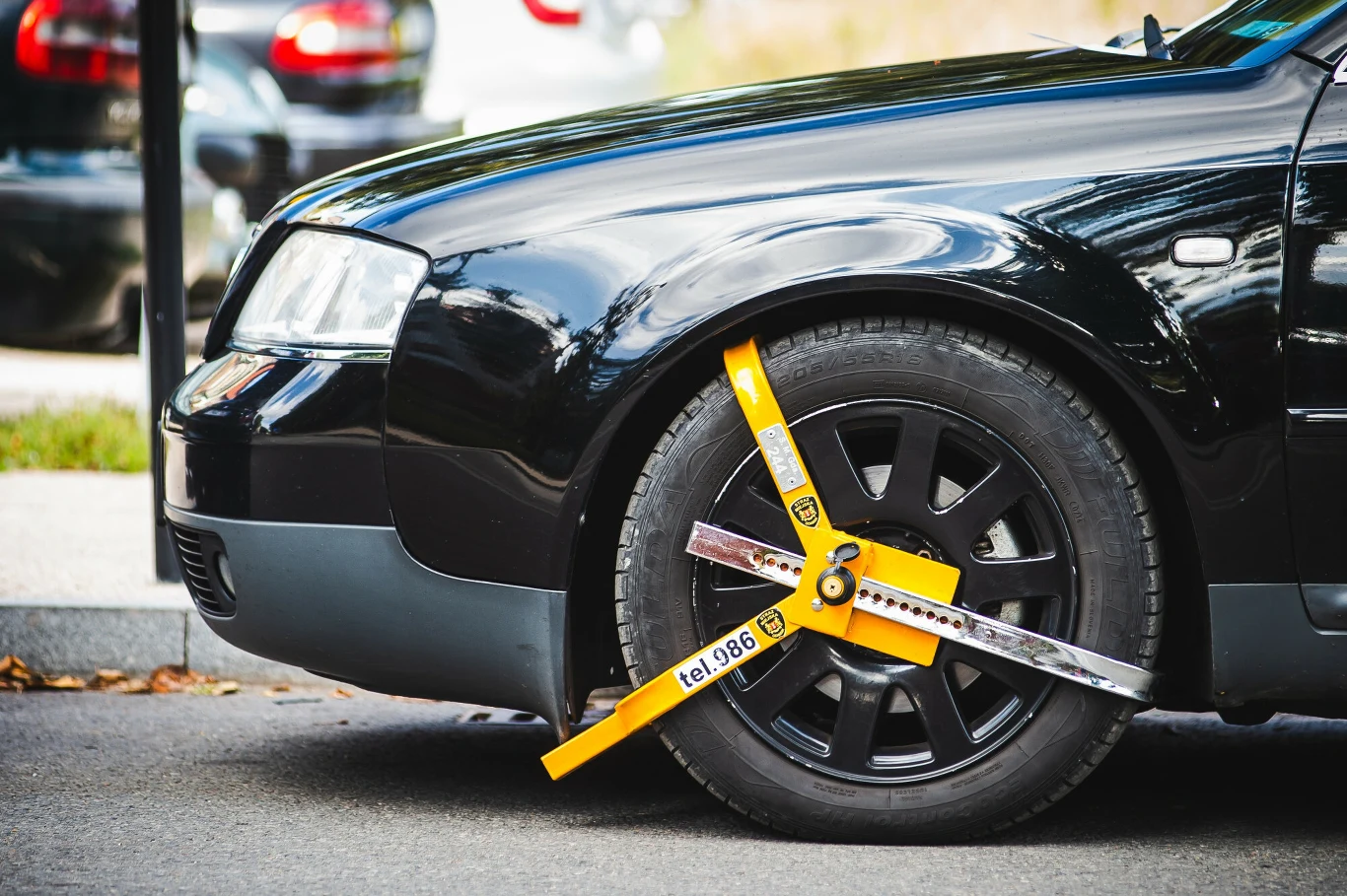 Pierwsze przewinienie będzie odpuszczane? Bratysława chce zmian w przepisach Czarne auto z blokadą na przednie koło, żółte urządzenie blokujące ruch pojazdu na ulicy w Bratysławie