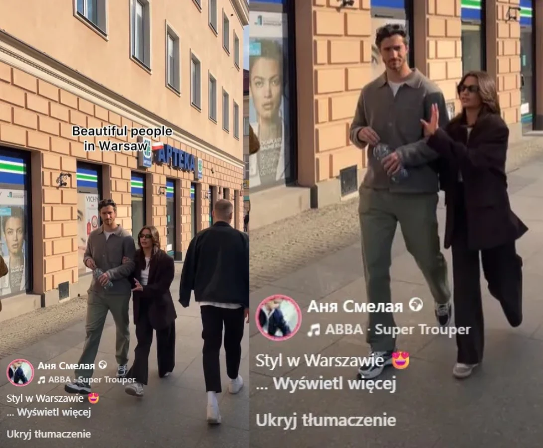 Para idąca chodnikiem w centrum Warszawy; kobieta w ciemnych okularach obejmuje wysokiego mężczyznę, oboje ubrani modnie i nonszalancko, w tle mijają ich przechodzień oraz charakterystyczna fasada budynków z dużymi reklamami na witrynach.