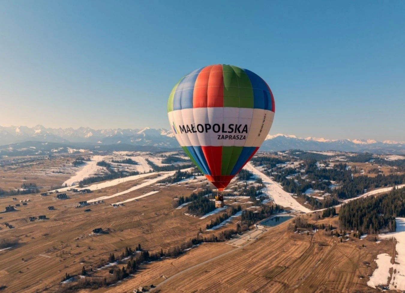 W przedostatni weekend marca 2026 na małopolskim niebie pojawią się niesamowite balony. Wszystko w ramach festiwalu "Odlotowa Małopolska"./ zdj. mot.krakow.pl Kolorowy balon w powietrzu. Pod nim pola uprawne, domy i lasy. W tle góry. Festiwal "Odlotowa Małopolska".