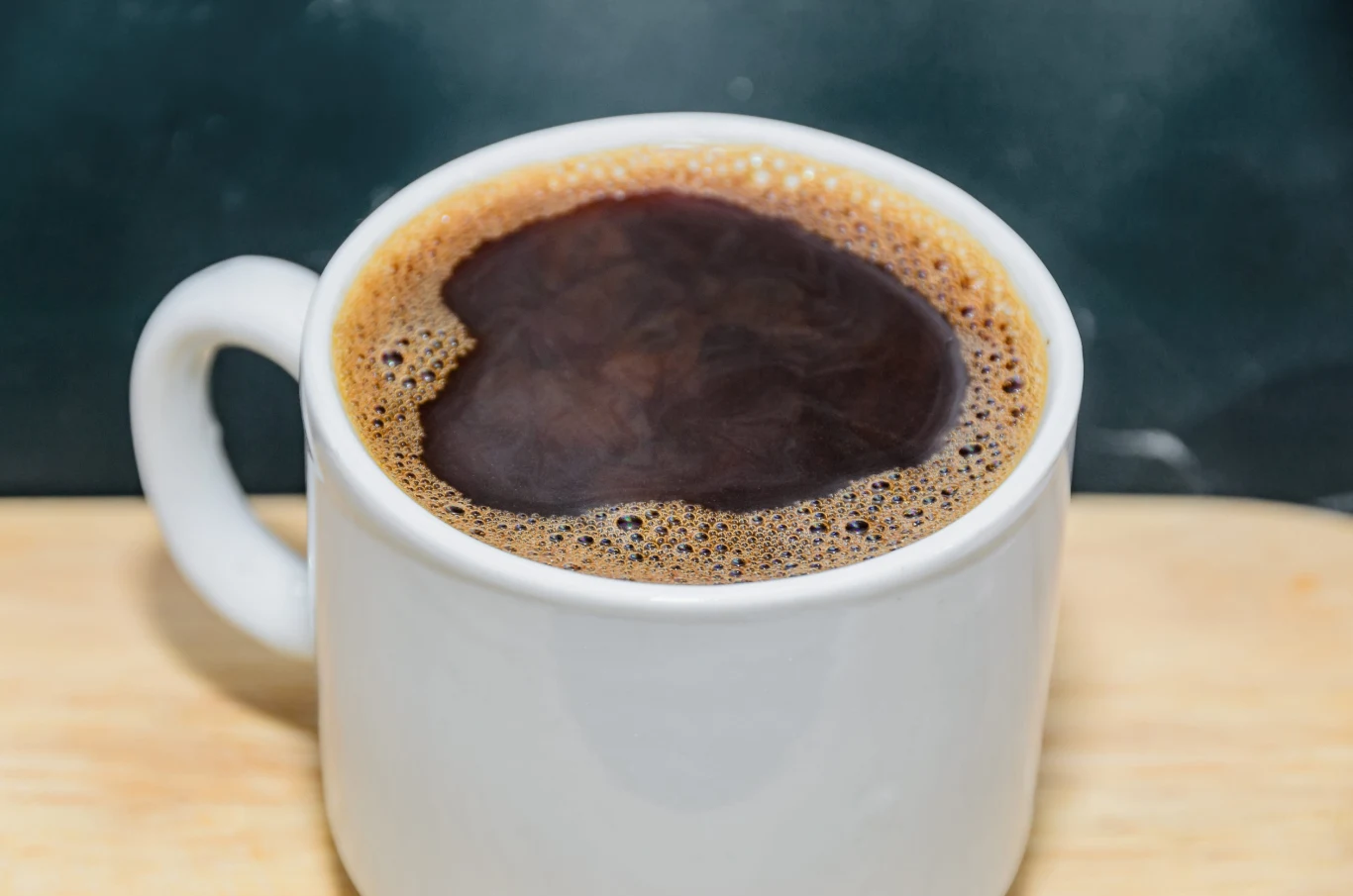 Była popularna w PRL-u, całe rodziny piły ją do śniadania. Biała filiżanka z kawą zbożową z pianką, na jasnym drewnianym blacie, popularna w czasach PRL-u.