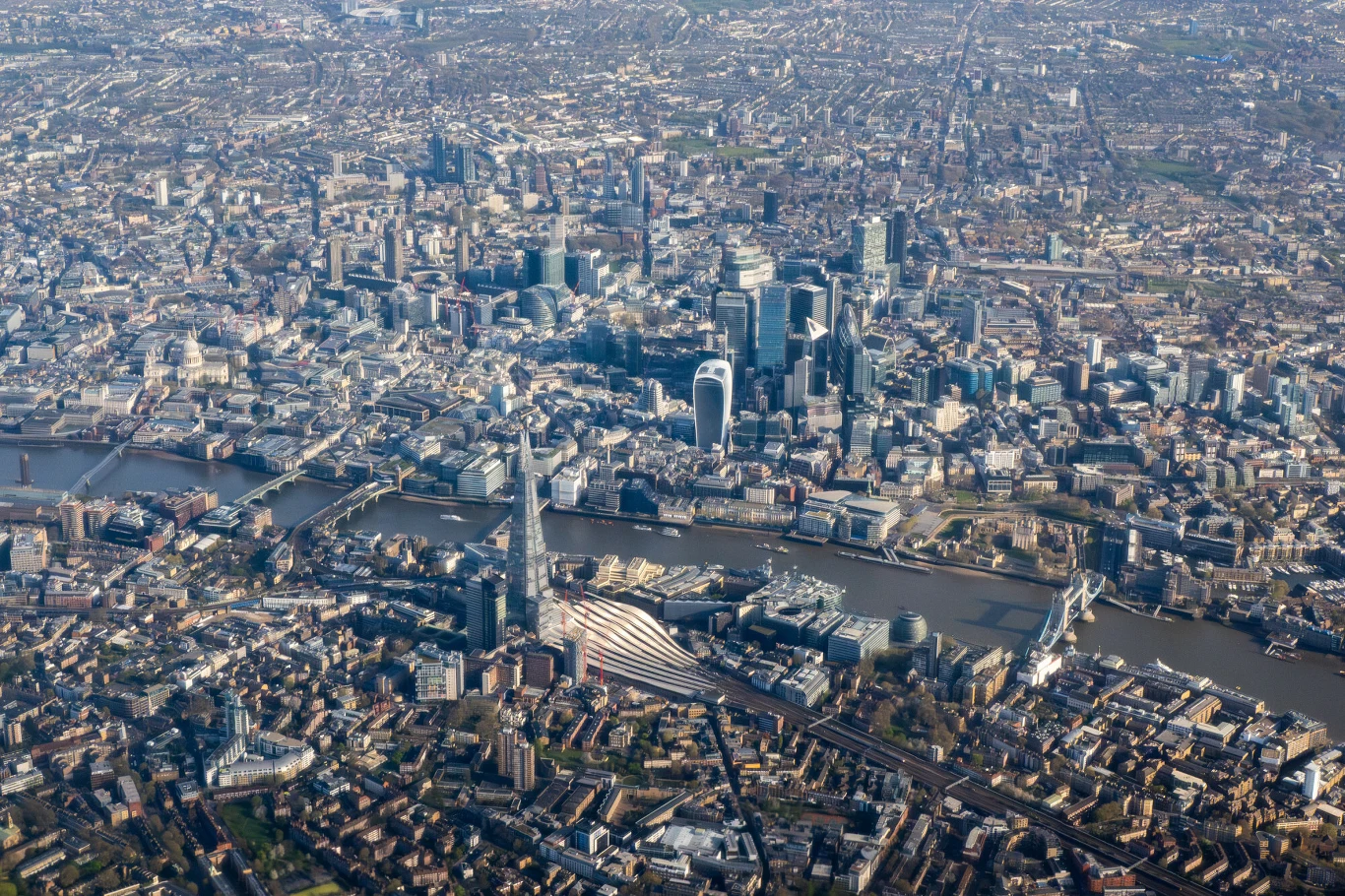 panorama centrum Londynu z wyraźnie widocznymi nowoczesnymi wieżowcami, charakterystycznym wieżowcem The Shard oraz rzeką Tamizą przepływającą przez miasto