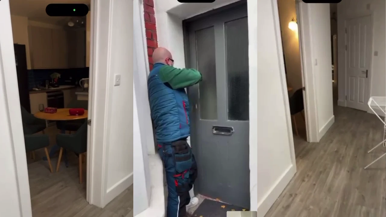 Mężczyzna w niebieskiej kamizelce i okularach wybija szybę w drzwiach wejściowych za pomocą narzędzia, podczas gdy wnętrze mieszkania jest częściowo widoczne po obu stronach kadru.