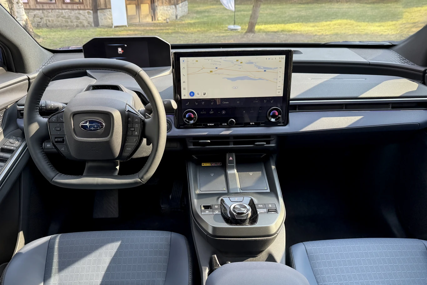 nowoczesny kokpit samochodu z dużym ekranem dotykowym na konsoli środkowej, cyfrowymi wskaźnikami za kierownicą i kierownicą z wieloma przyciskami sterującymi